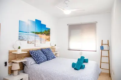 a bedroom with a bed and a painting on the wall at VALDECARRETAS Apartamento Rota cerca de playa in Rota