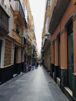 an alley with people walking down a street between buildings at Apartamentos Valverde Cádiz 1 - A in Cádiz