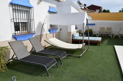 a pair of chairs and a hammock on a patio at LOS TOCHOS in Chiclana de la Frontera