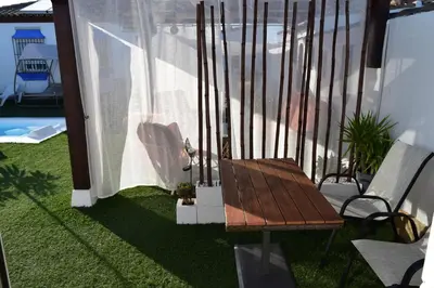 a balcony with a table and chairs on the grass at LOS TOCHOS in Chiclana de la Frontera