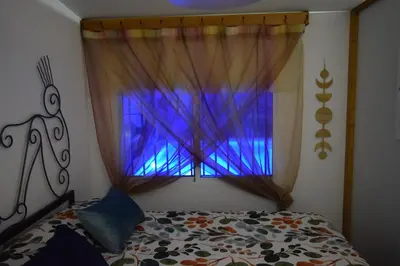 a bedroom with a bed and a window with purple curtains at LOS TOCHOS in Chiclana de la Frontera