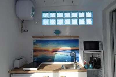 a kitchen with a sink and a painting on the wall at LOS TOCHOS in Chiclana de la Frontera