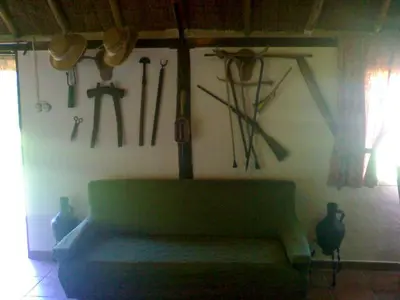 a living room with a green couch and tools hanging on a wall at Bright House in Sanlúcar – Fireplace in Sanlúcar de Barrameda