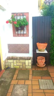 a patio with two pots of plants on a wall at Bright House in Sanlúcar – Fireplace in Sanlúcar de Barrameda