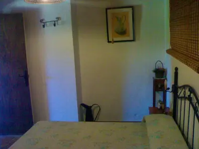 a bedroom with a bed and a wall with a picture at Bright House in Sanlúcar – Fireplace in Sanlúcar de Barrameda