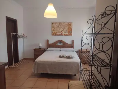 a bedroom with a bed with shoes on it at Chalet Santi Playa de la Barrosa in Chiclana de la Frontera