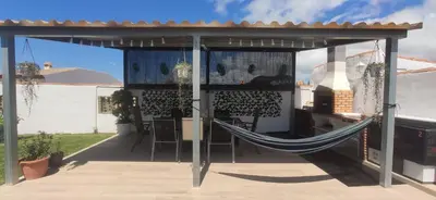 a hammock in a pergola on a patio at Chalet Santi Playa de la Barrosa in Chiclana de la Frontera