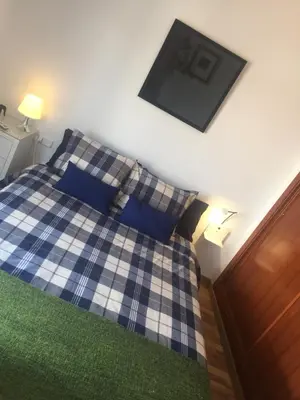 a bedroom with a blue and white bed with pillows at La terraza de San Pedro in Cádiz