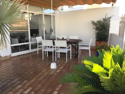 a patio with a table and chairs and plants at La terraza de San Pedro in Cádiz