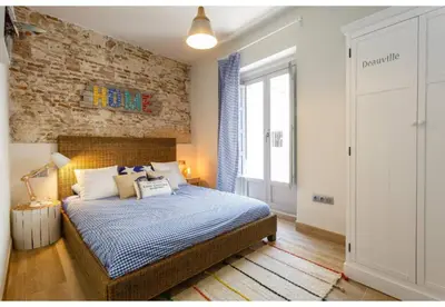 a bedroom with a bed and a brick wall at TERRAZA-Caleta Beach Home by Cadiz4Rentals in Cádiz