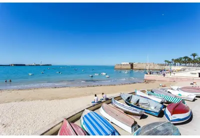 a group of boats sitting on the beach at TERRAZA-Caleta Beach Home by Cadiz4Rentals in Cádiz
