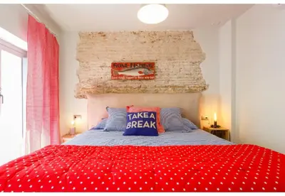 a bedroom with a red bed with a sign on the wall at TERRAZA-Caleta Beach Home by Cadiz4Rentals in Cádiz