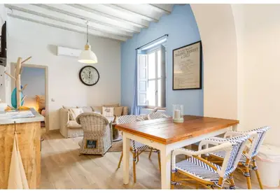 a dining room and living room with a table and chairs at PATIO-Caleta Beach Home by Cadiz4Rentals in Cádiz