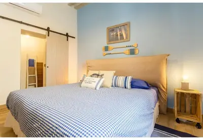 a bedroom with a bed with a blue and white comforter at PATIO-Caleta Beach Home by Cadiz4Rentals in Cádiz