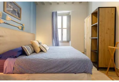 a bedroom with a bed with pillows and a window at PATIO-Caleta Beach Home by Cadiz4Rentals in Cádiz