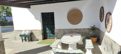 a patio with a table and chairs in front of a building at Casa Rural El Romeral in Medina Sidonia