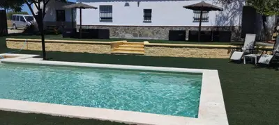 a swimming pool in the middle of a yard with a house at Casa Rural El Romeral in Medina Sidonia