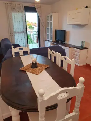 a dining room table and chairs with a table and a couch at Coto la Campa in Chiclana de la Frontera