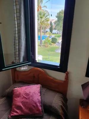 a bedroom with a window and a bed with a pillow at Coto la Campa in Chiclana de la Frontera