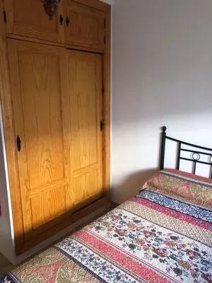 a bedroom with two beds and a wooden door at Casas Juani- chalet con piscina in Conil de la Frontera