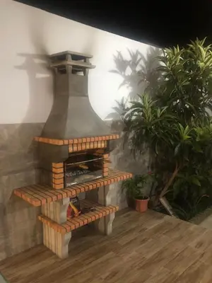 a stone fireplace sitting on top of a wooden floor at Casas Juani- chalet con piscina in Conil de la Frontera