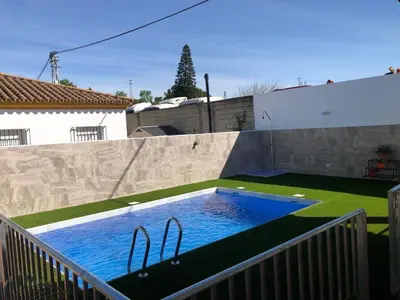 a swimming pool in the backyard of a house at Casas Juani- chalet con piscina in Conil de la Frontera