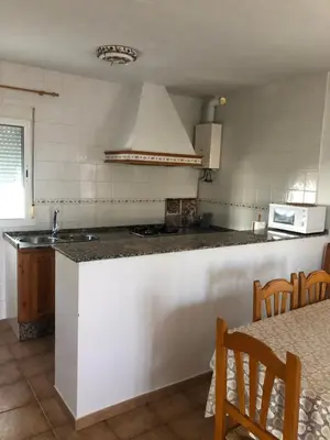 a kitchen with a counter and a stove top oven at Casas Juani- chalet con piscina in Conil de la Frontera