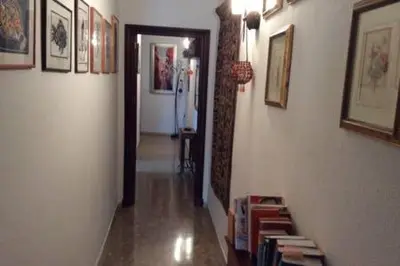 a hallway with books on the walls and a hallway with a hallwayngthngthngth at Homestay en Plaza Candelaria, Casco Antiguo in Cádiz