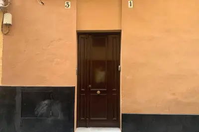 a building with a black door and a wall at Apartamento Plaza Viuda in Cádiz