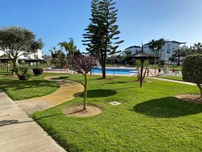 a park with a tree and a swimming pool at Apartamento en Bahia Golf - Costa Ballena in Costa Ballena