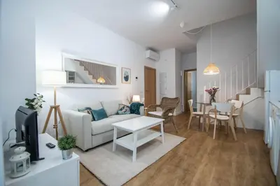 a living room with a couch and a table at Duplex Flamingo Cadiz in Cádiz