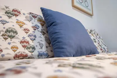 a blue pillow sitting on a couch with a blanket at Duplex Flamingo Cadiz in Cádiz