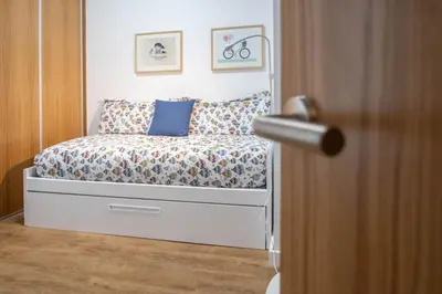 a bedroom with a bed with blue pillows at Duplex Flamingo Cadiz in Cádiz