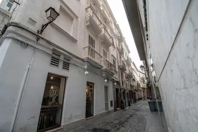 an empty alley way with a building and a shop at Duplex Flamingo Cadiz in Cádiz