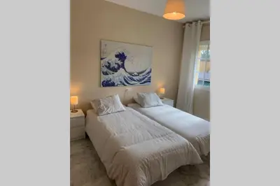 a bedroom with a bed and a painting of a wave at VIVE JEREZ Casa de lujo con piscina y barbacoa en la mejor zona de Jerez de la Frontera in Jerez de la Frontera