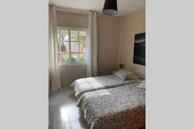 a bedroom with two beds and a window at VIVE JEREZ Casa de lujo con piscina y barbacoa en la mejor zona de Jerez de la Frontera in Jerez de la Frontera