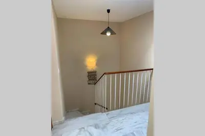 a room with a staircase and a light on the wall at VIVE JEREZ Casa de lujo con piscina y barbacoa en la mejor zona de Jerez de la Frontera in Jerez de la Frontera