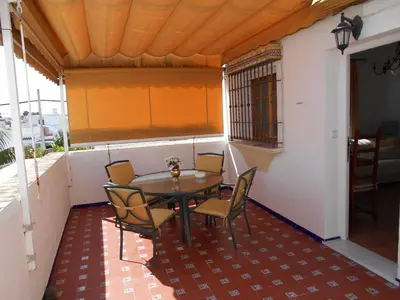 a table and chairs on the balcony of a house at Apartamento Playa de Regla, Aire acondicionado, Garaje in Chipiona