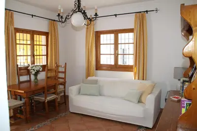 a living room with a white couch and a table at Apartamento Playa de Regla, Aire acondicionado, Garaje in Chipiona