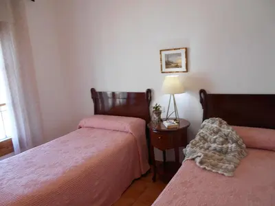 a bedroom with two beds and a table with a lamp at Apartamento Playa de Regla, Aire acondicionado, Garaje in Chipiona