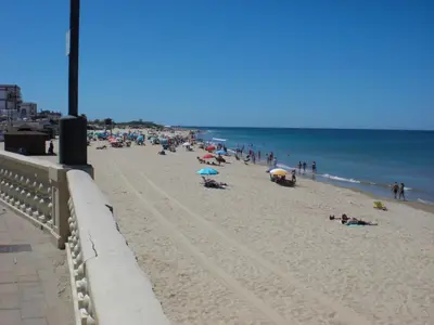 a group of people on a beach with the ocean at Apartamento Playa de Regla, Aire acondicionado, Garaje in Chipiona