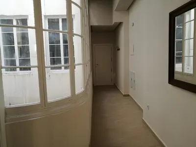 an empty hallway with two windows and a door at Apartamentos Valverde Cádiz 1-B in Cádiz