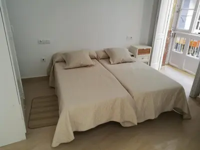 a bedroom with a large bed in a white room at Apartamentos Valverde Cádiz 1-B in Cádiz