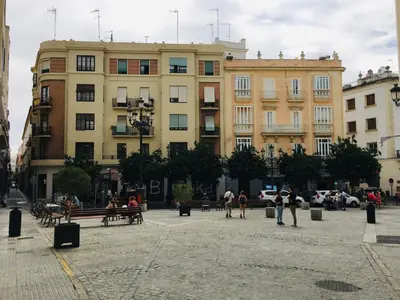 a group of people walking in a plaza in front of buildings at Apartamentos Valverde Cádiz 1-B in Cádiz