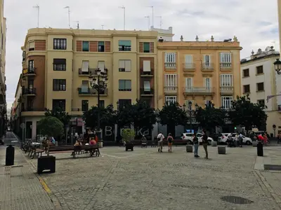 a group of people walking in a plaza in front of a building at Apartamentos Valverde Cádiz 1-B in Cádiz