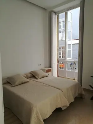 a white bedroom with a large bed and a window at Apartamentos Valverde Cádiz 1-B in Cádiz