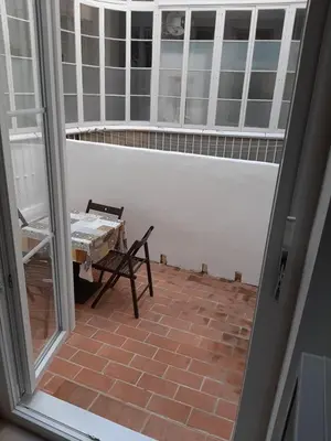 an open door to a patio with a table and chair at Apartamentos Valverde Cádiz 1-C in Cádiz