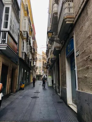 two people walking down a street in an alley at Apartamentos Valverde Cádiz 1-C in Cádiz