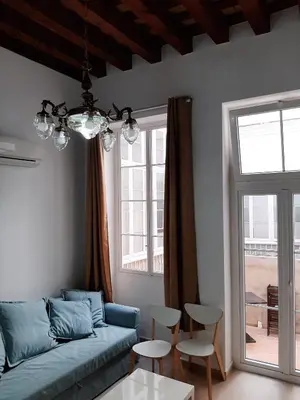 a living room with a blue couch and a table at Apartamentos Valverde Cádiz 1-C in Cádiz