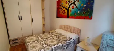 a bedroom with a bed and a painting on the wall at Bonito apartamento Cádiz centro in Cádiz